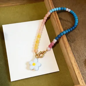 Detailed view of dopamine style glass beaded necklace with white flower pendant