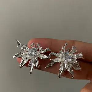Close-up view of elegant silver flower earrings with sparkling central zircon stones