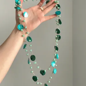 Dettaglio che mostra la trama delle perle di conchiglia verdi su questa collana vintage