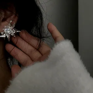 Close-up of elegant French luxury 3D flower earrings with sparkling zircons.
