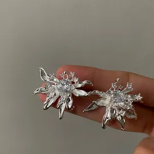 Close-up detail of elegant silver-toned flower stud earrings with cubic zirconia