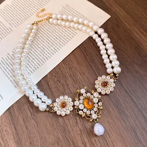 Vintage court style double-strand pearl necklace with amber resin and flower pendant details