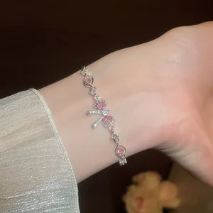 Close-up detail of a sweet sparkling pink zircon bow flower bracelet worn on a wrist