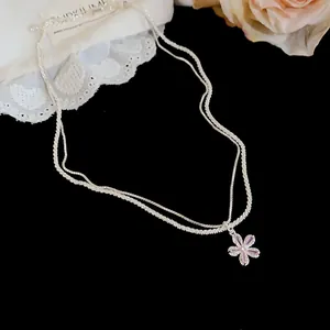 Detailed view of a sparkling double-layer silver necklace with a zircon flower pendant.