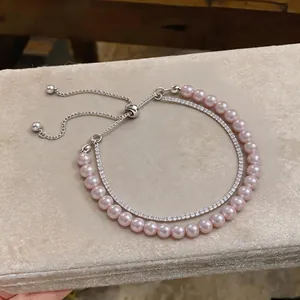 Elegant double-layer bracelet featuring pink pearls and zircon stones with adjustable slider