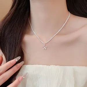 Close-up of sparkling zircon flower pendant necklace worn by a model in sweet style
