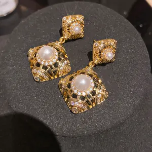 Primo piano di orecchini vintage in oro con perle e zirconi brillanti dal design elegante.