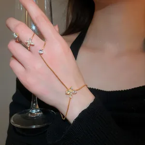 Close-up detail of an elegant gold zircon flower integrated bracelet ring worn on a hand