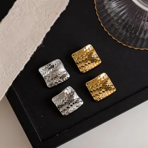 Vista macro che mostra il motivo a diamante delle orecchie placcate in oro 18 carati e argento
