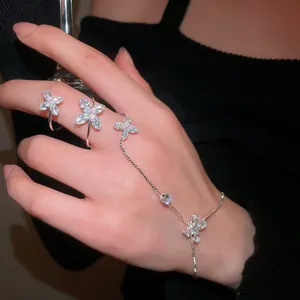 Elegant silver flower zircon hand chain ring integrated bracelet shown on model's hand.