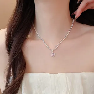 Macro view of dainty silver double-strand necklace with sparkling zircon flower pendant