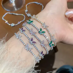 Close-up of layered butterfly tennis bracelets with colorful zircon stones on wrist.