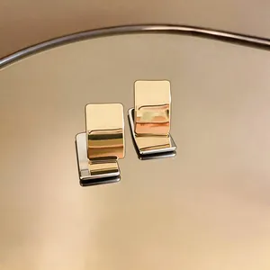 Gedetailleerde close-up van minimalistische 18k vergulde vierkante knopoorbellen
