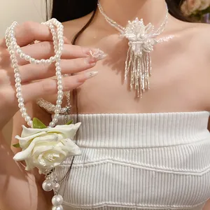 Detalle de la elegante rosa de tela blanca y el collar de perlas de doble capa para mujer