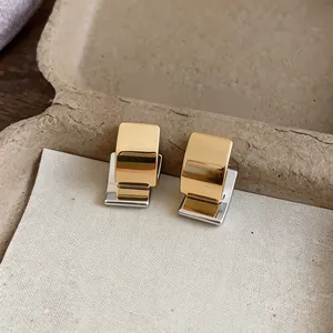 Detailopname van tweekleurige geometrische 18k vergulde vierkante oorknopjes goud