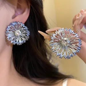 Primer plano de elegantes pendientes de flores de metal con un brillante de estrás