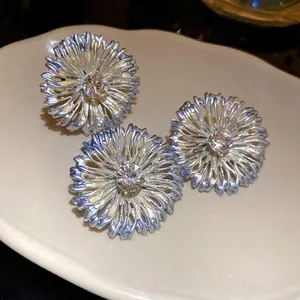 Primer plano detallado de anillos de flores metálicas con piedras facetadas