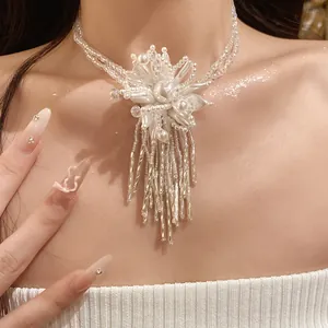Primer plano de elegante collar de perlas de doble capa con colgante de flor blanca y borlas
