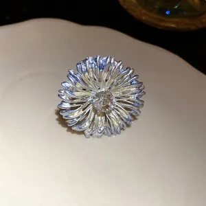 Primer plano detallado del anillo de flor azul metálico con un cristal central resplandeciente