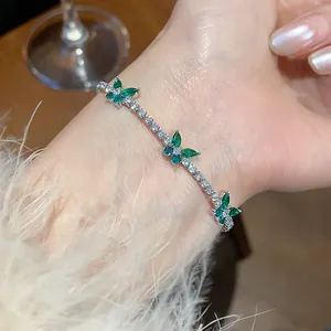 Elegant detail of a sparkling green and white zircon butterfly bracelet worn on a wrist