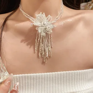 Detalle de cerca de un collar de flores de cuentas blancas de dos capas con flecos