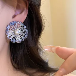 Primer plano de un elegante pendiente de flor plateada con un circón brillante
