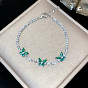 Detailed view of a silver-tone bracelet with sparkling green zircon butterflies.