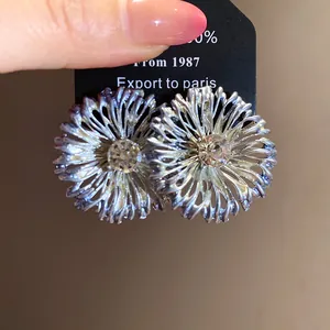 Primer plano de joyas metálicas en forma de flor con detalles de cristales