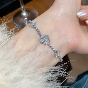 Detailed close-up of an elegant zircon flower bracelet on a wrist with fuzzy white sleeve