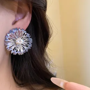 Primer plano de elegante pendiente floral con acabado metálico y diamantes de imitación