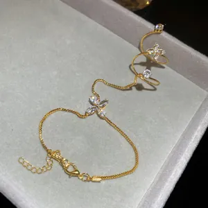 Detailed view of gold-tone zircon flower hand chain with integrated bracelet and ring