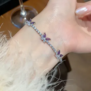 Close-up of elegant silver bracelet with purple and white zirconia butterfly charms
