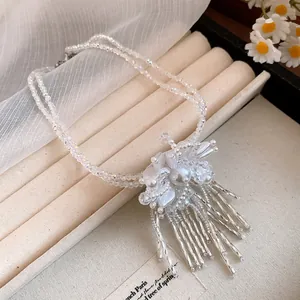 Primer plano del collar de cuentas de doble capa con un colgante de flor elegante