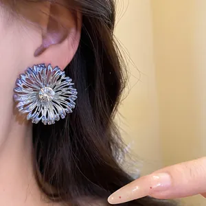 Vista macro detallada de un pendiente de flor metálica grande con diamantes de imitación