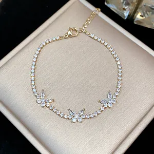 Close-up detail of a sparkling gold butterfly zircon bracelet on a jewelry box.