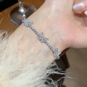 Close-up detail of a delicate silver zircon butterfly bracelet worn on a female wrist