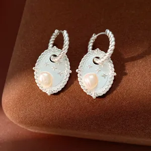 Dettaglio ravvicinato di orecchini retrò in argento con perla e zircone