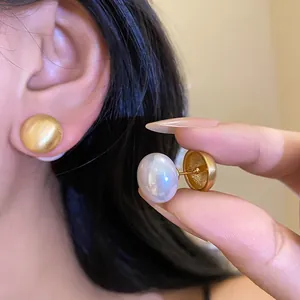 Dettaglio di orecchini versatili tondi in oro spazzolato e perle per donne eleganti