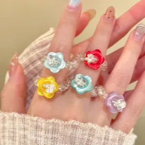 Bunte Blumenringe aus Harzperlen an der Hand für einen trendigen Dopamin-Mode-Look
