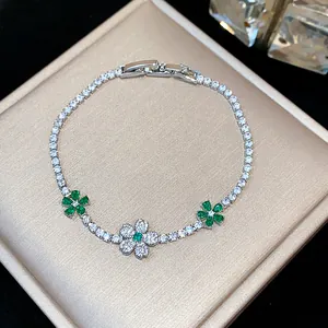 Close-up of elegant tennis bracelet with emerald green and clear zircon flowers