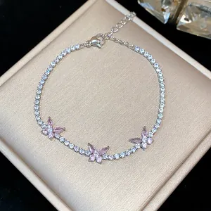 Detailed macro view of sparkling zircon butterfly bracelet with pink marquise stones on gift box