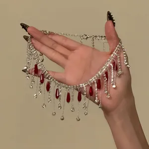 Detail view of sparkly Y2K fringe choker with red glass drops held in hand