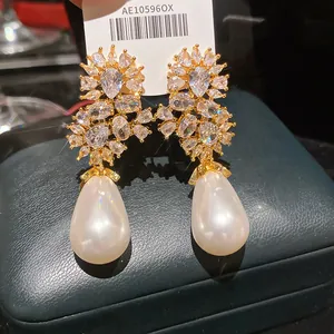 Dettaglio ravvicinato di eleganti orecchini pendenti con fiori di zircone e perle