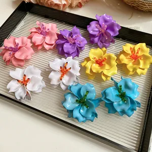 Detailed macro view of colorful 3D acrylic flower earrings with delicate beaded centers.