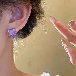 Primo piano di eleganti orecchini quadrati viola a goccia d'olio, stile retrò