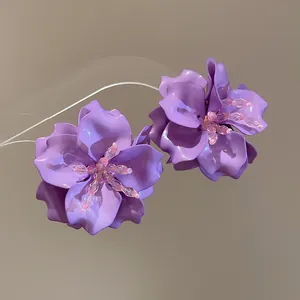 Close-up of purple acrylic 3D flower earrings with delicate bead detailing.