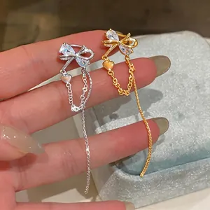 Elegant butterfly tassel ear clips with heart charms for non-pierced ears in gold and silver.