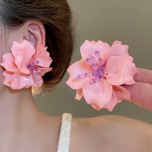 Close-up of pink 3D acrylic flower earrings with purple beaded stamens detail shown