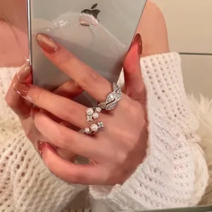 Detailansicht eines eleganten silbernen Zirkon-Doppelschichtrings und Perlenrings.
