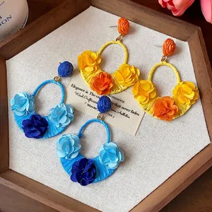 Bohemian handmade raffia hoop earrings decorated with colorful fabric flowers